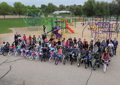 dozens of kids with bikes outside in a playground