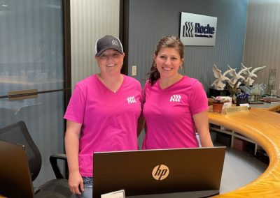 two women in pink shirts smiling